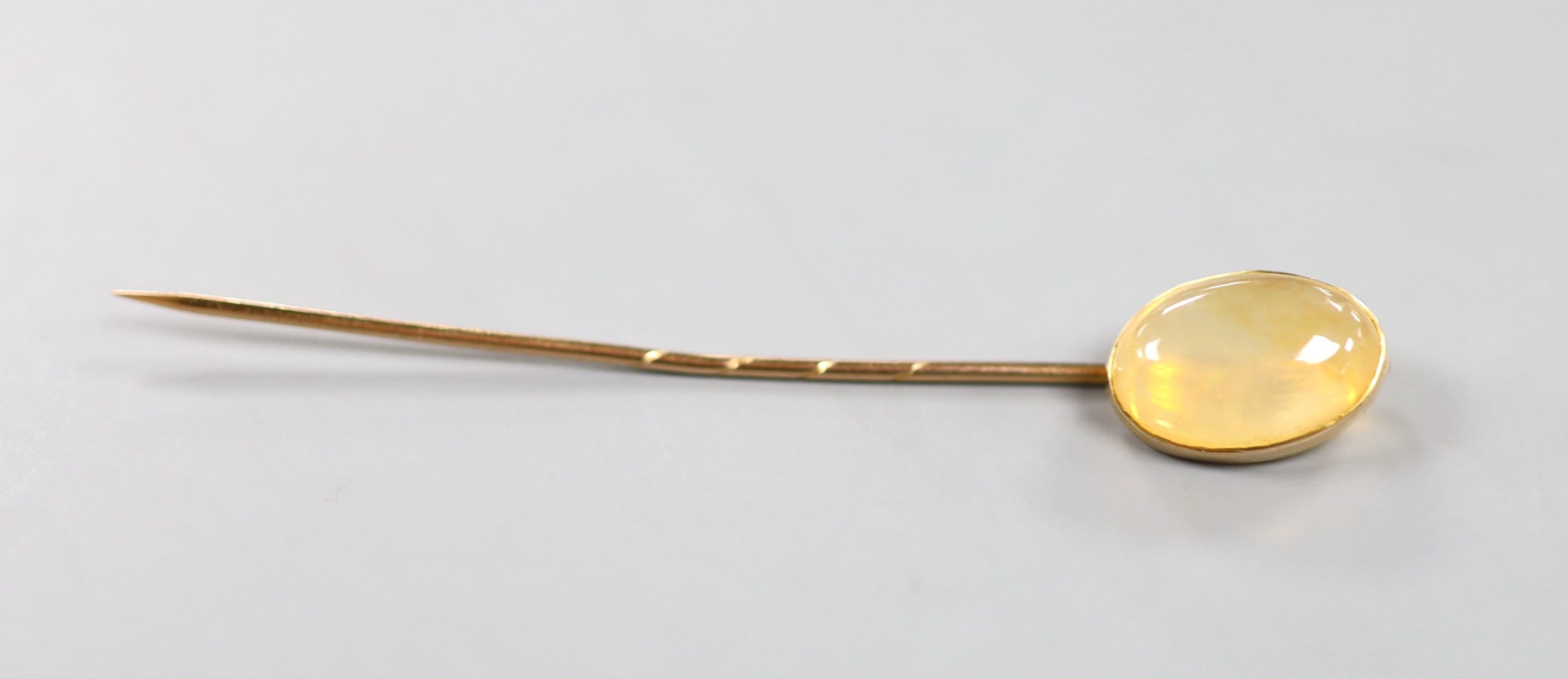 An early 20th century yellow metal and opal? set stick pin, 7cm, gross weight 2.4 grams.